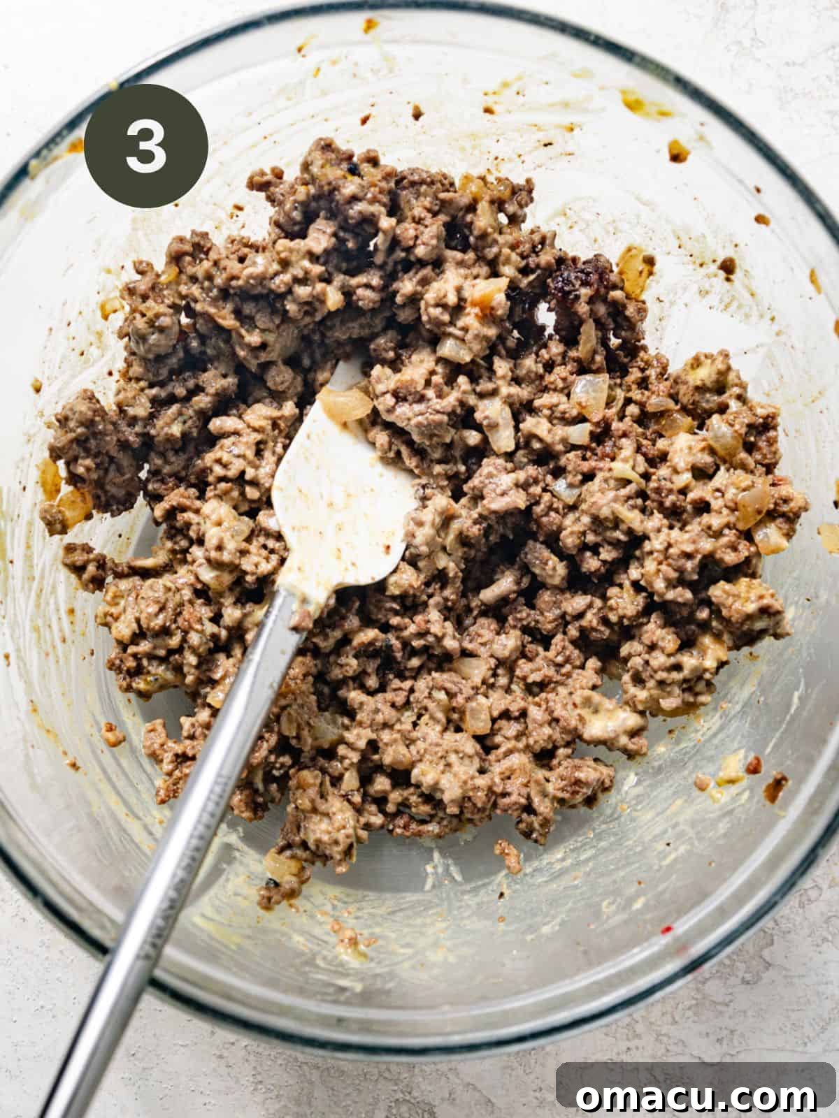 Cooked ground beef mixture combined with a portion of the burger sauce in a mixing bowl, ready for assembly.
