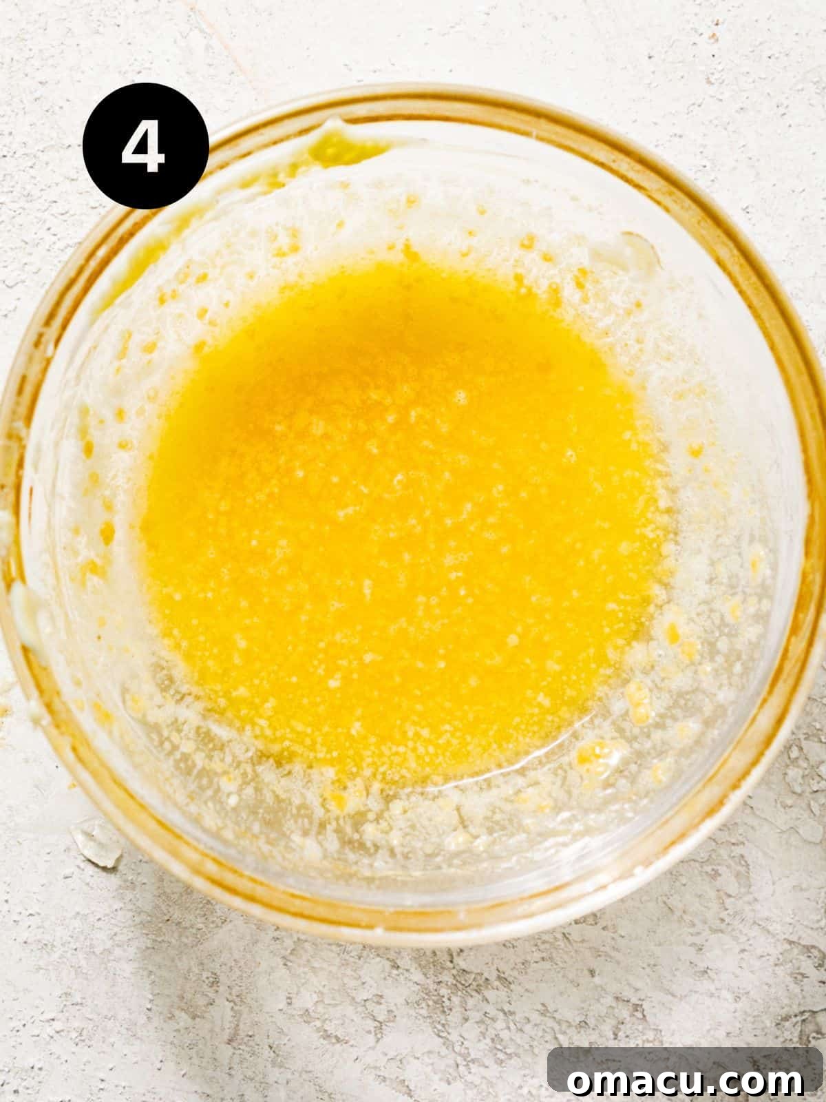 Melted butter, fresh parsley, and minced garlic mixed together in a small bowl to create the aromatic butter topping.
