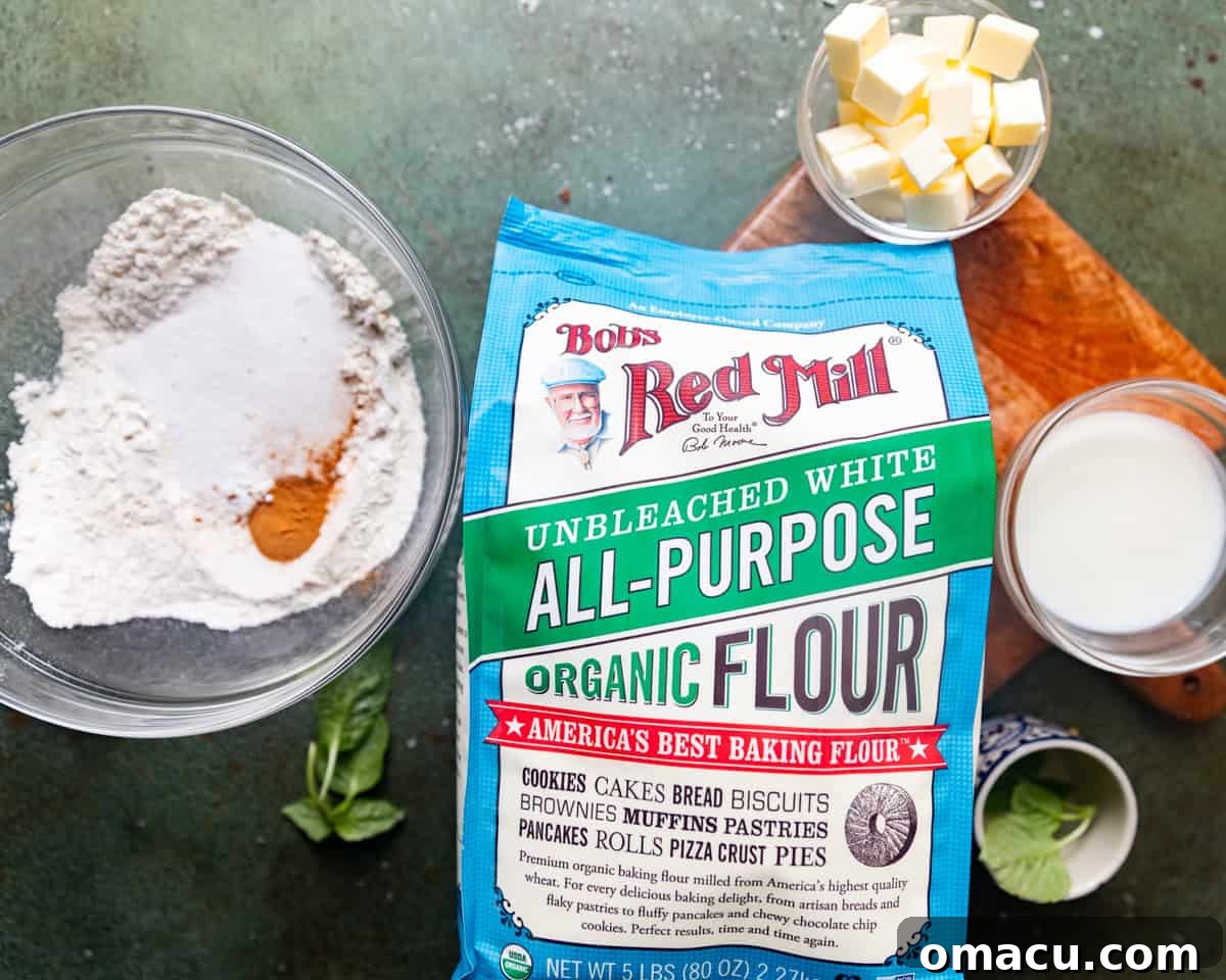 A collection of ingredients for the shortcake crumbles, including all-purpose flour, cinnamon, baking powder, cold buttermilk, cold salted butter, and kosher salt, neatly arranged in separate bowls.