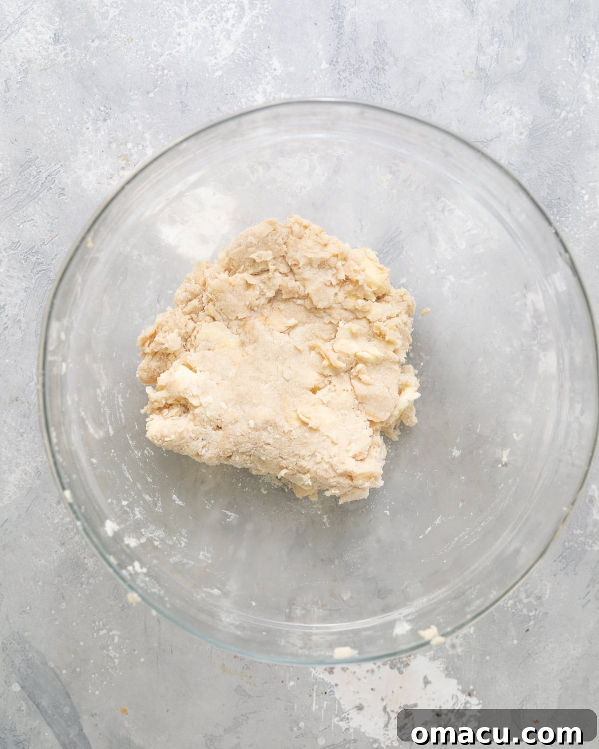 Shortcake dough, now formed into a cohesive ball, resting in a bowl after being gently kneaded.