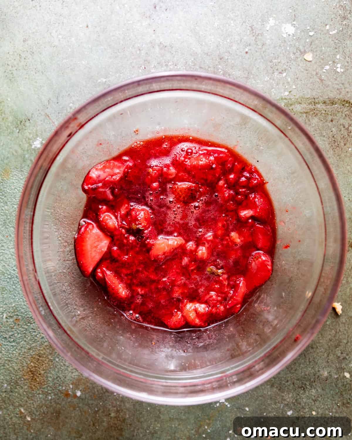 Roasted strawberries, now softened and vibrant, collected in a bowl, ready to be pureed into a concentrated strawberry flavor.