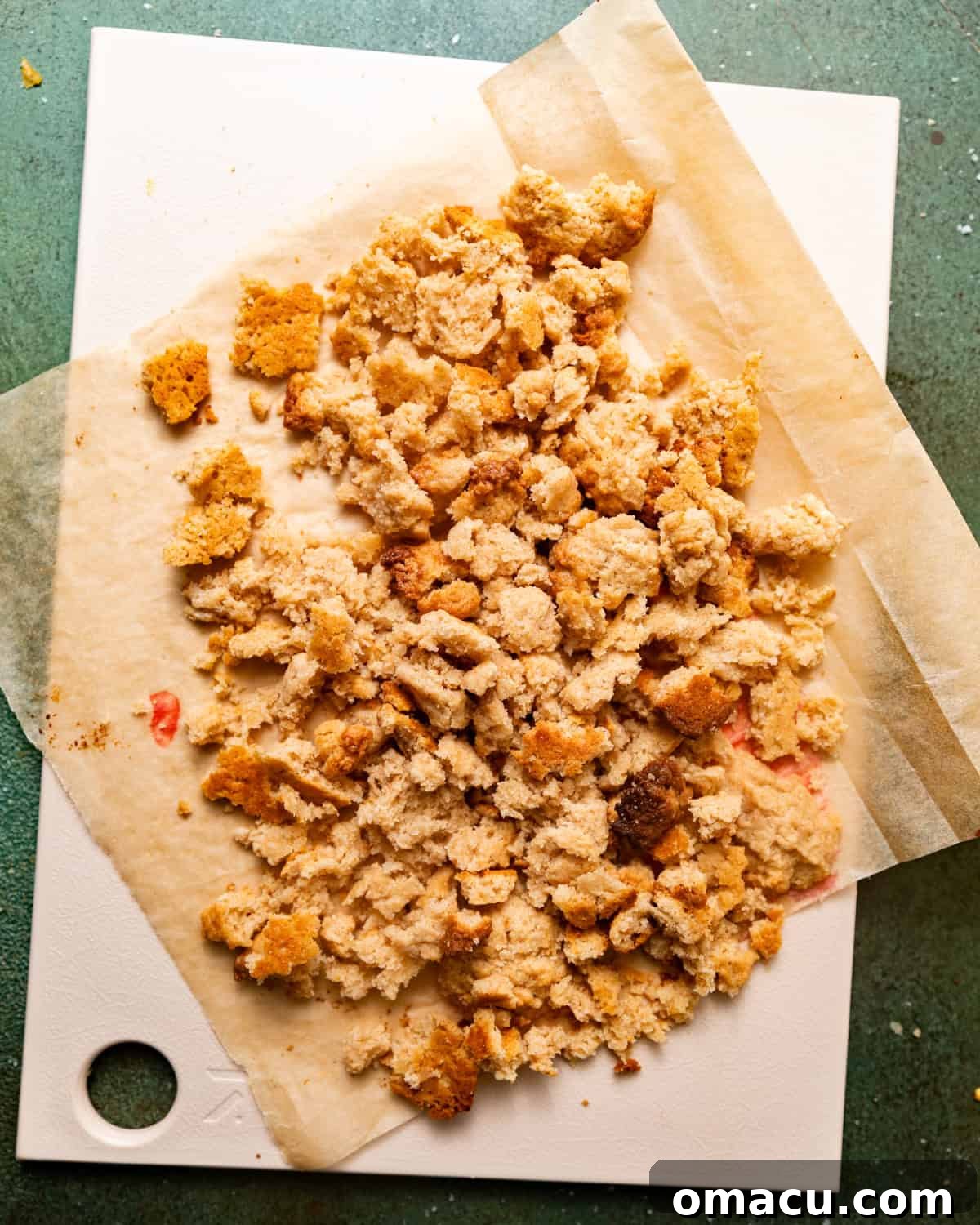 Baked shortcake crumbles, broken into smaller pieces, arranged on a cutting board, ready to be incorporated into the ice cream.