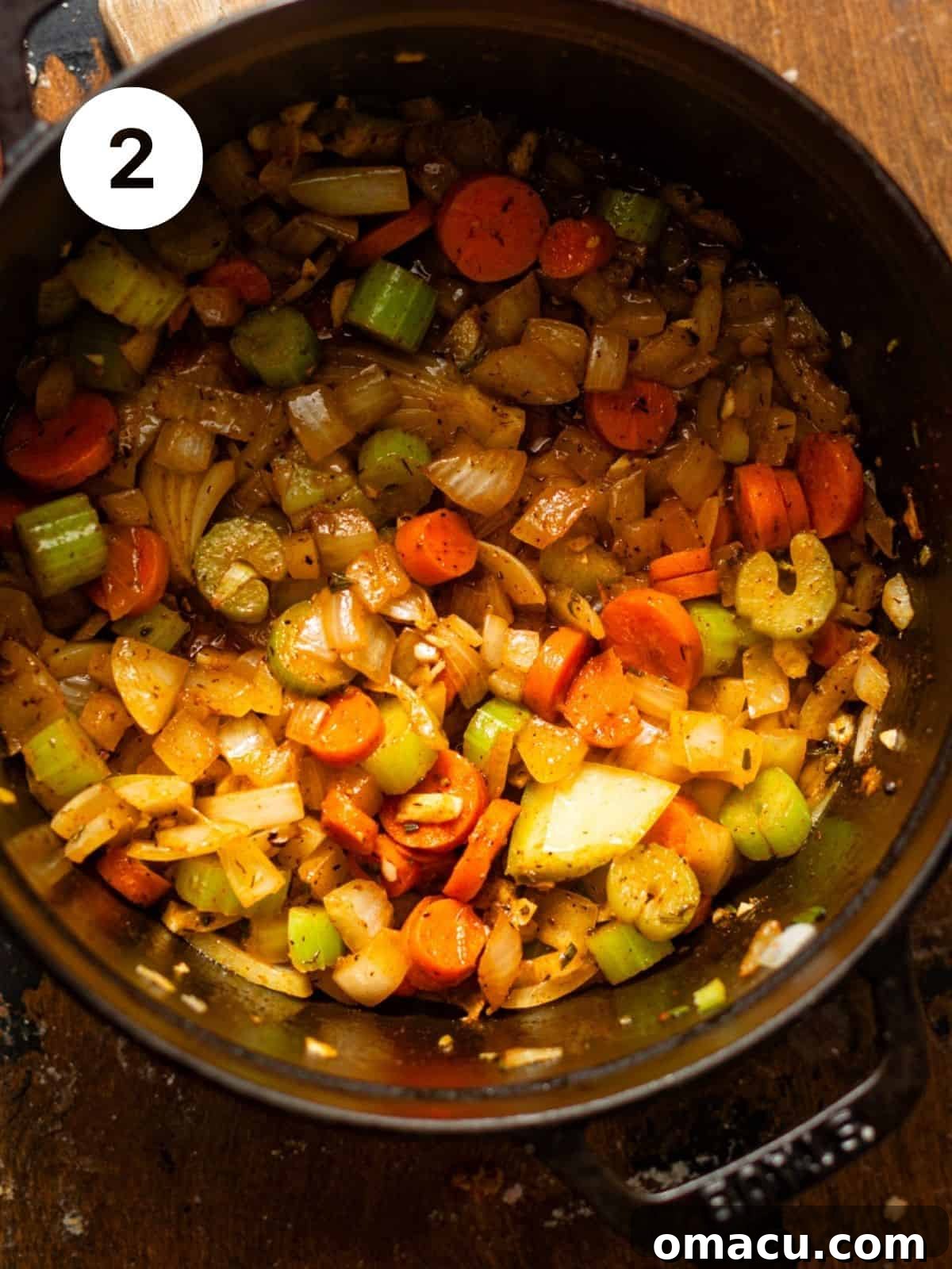 A dutch oven filled with chopped celery, carrots, and onions, gently sautéing in butter and olive oil, seasoned with salt and black pepper, to create an aromatic base for the soup.