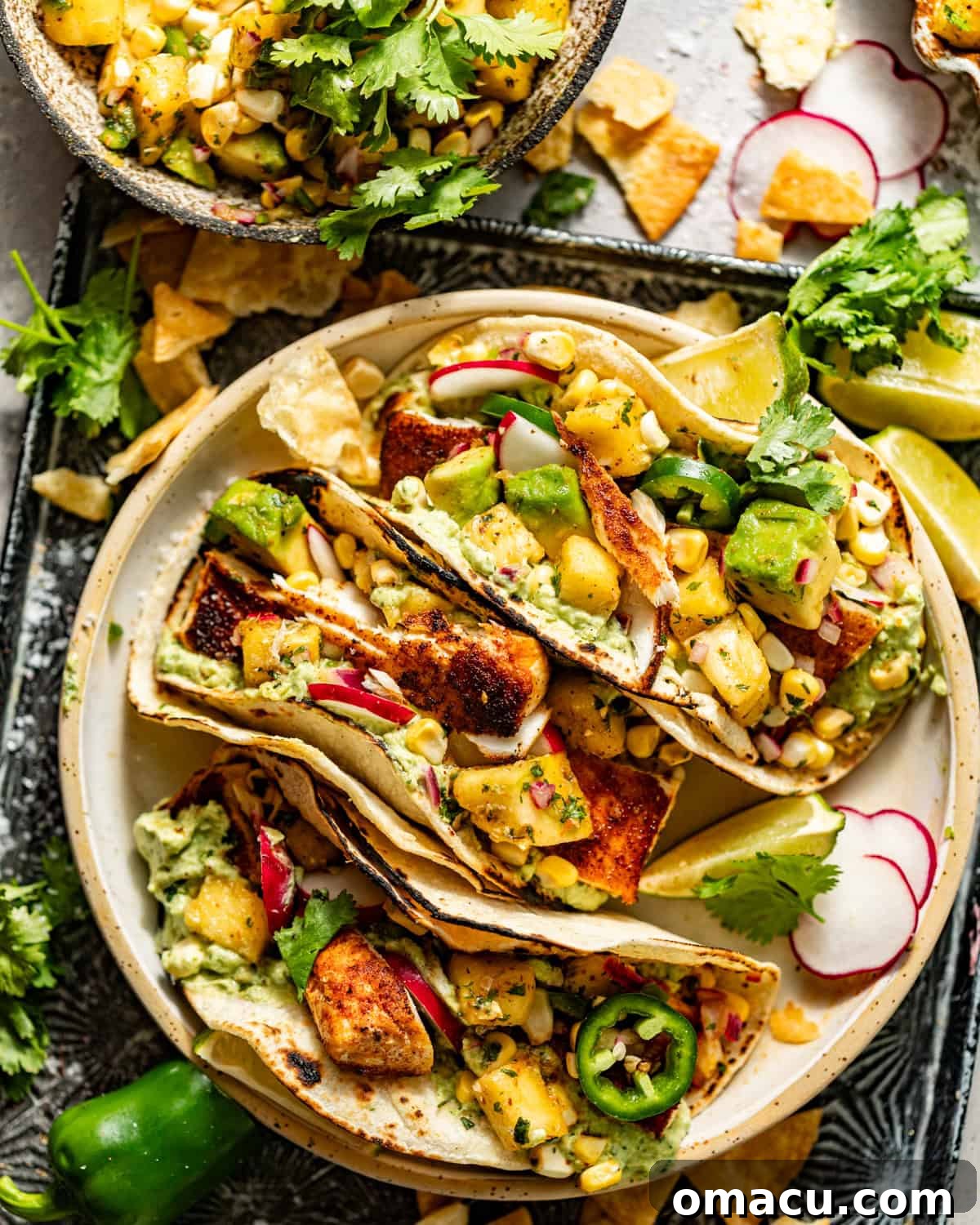 Exquisite blackened mahi mahi tacos generously topped with vibrant pineapple salsa and creamy avocado crema, beautifully arranged on a rustic serving plate, inviting a delicious meal.