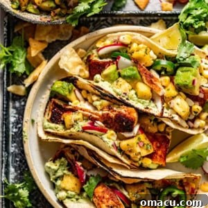 A close-up view of a perfectly plated mahi mahi taco, garnished with fresh pineapple salsa, vibrant cilantro, and a zesty lime wedge, indicating a delightful culinary experience.