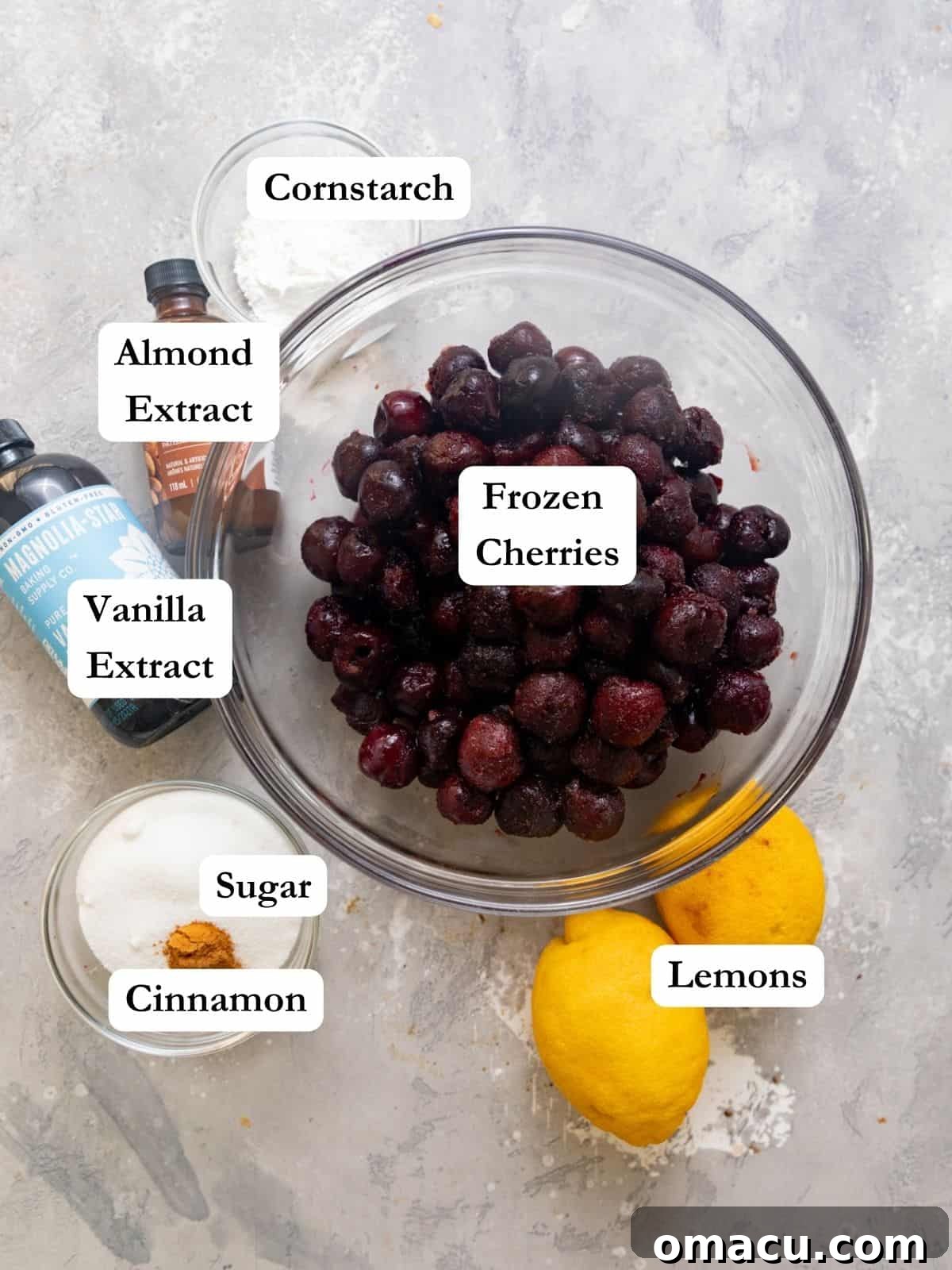 A vibrant display of cherry cobbler filling ingredients, including frozen cherries, fresh lemon juice, granulated sugar, cinnamon, vanilla extract, almond extract, and cornstarch, on a light background.