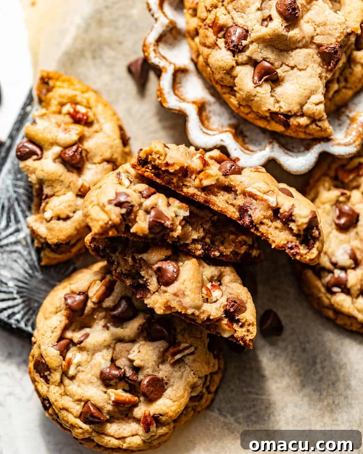 A perfectly baked banana chocolate chip cookie, cut in half to show its soft, gooey center with melted chocolate, resting on parchment paper.