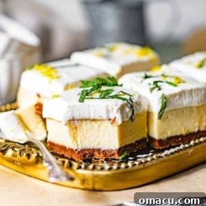 An up close photo of key lime pie bars on a plate with spoons, showing off their creamy texture and golden biscoff crust, ready for a taste.