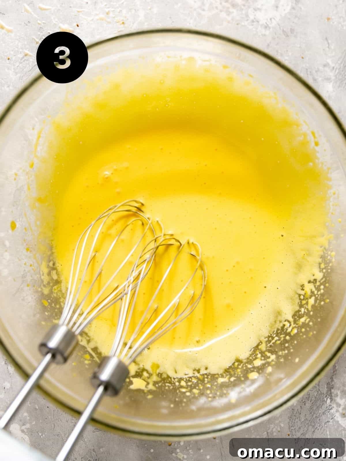 Expertly separated egg yolks in a bowl, beaten to a lighter color and frothy texture, ready for the key lime filling.