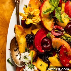 A close-up of the delicious Stone Fruit Salad, vibrant with colorful fruits and fresh mint, ready to be served.