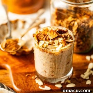 A top-down view of Almond Butter Overnight Oats in a mason jar, topped with fresh berries and a drizzle of almond butter.