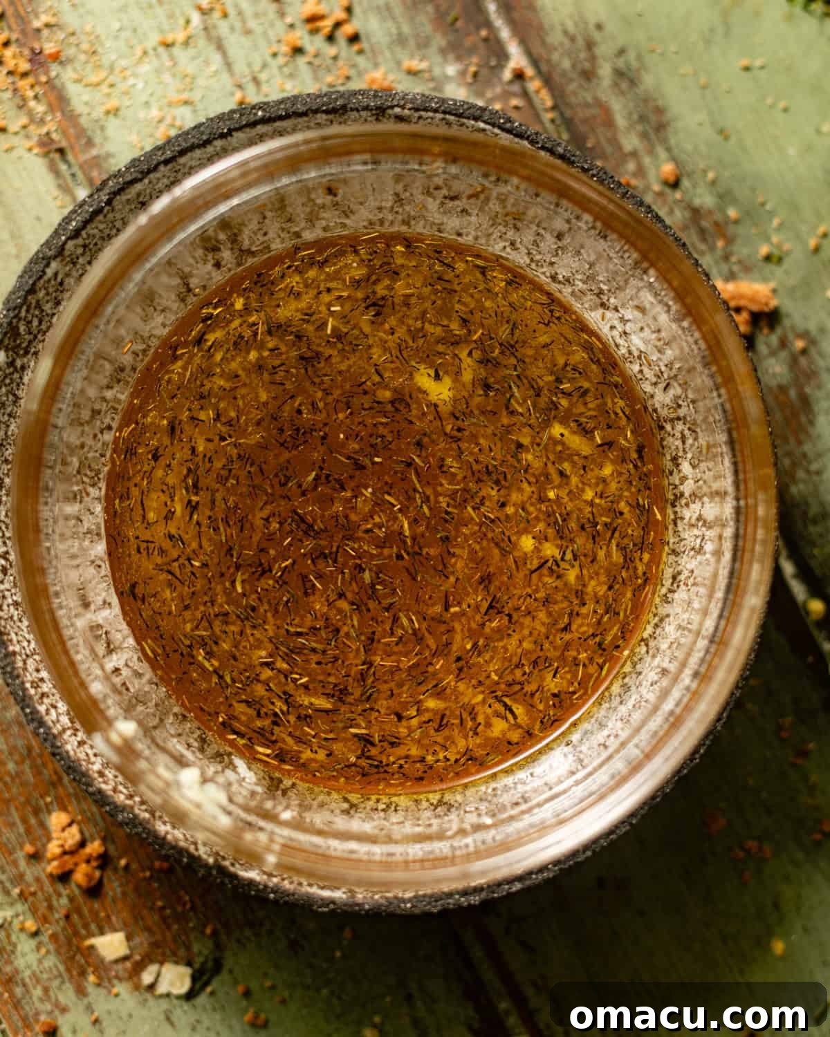 Maple vinaigrette being whisked together in a small bowl, showing the emulsion process.