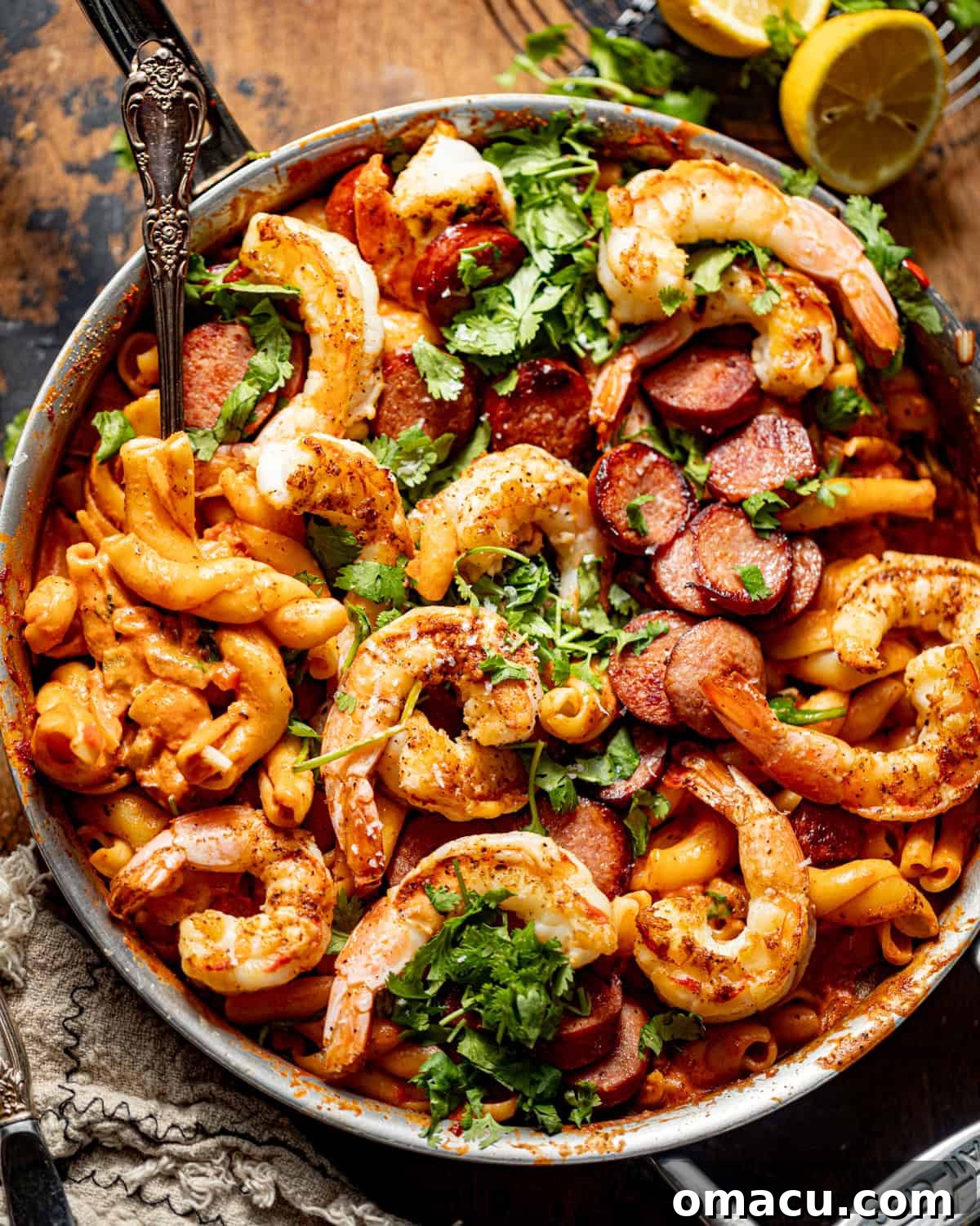Cajun shrimp and sausage pasta in a skillet, ready to be served, garnished with fresh parsley.