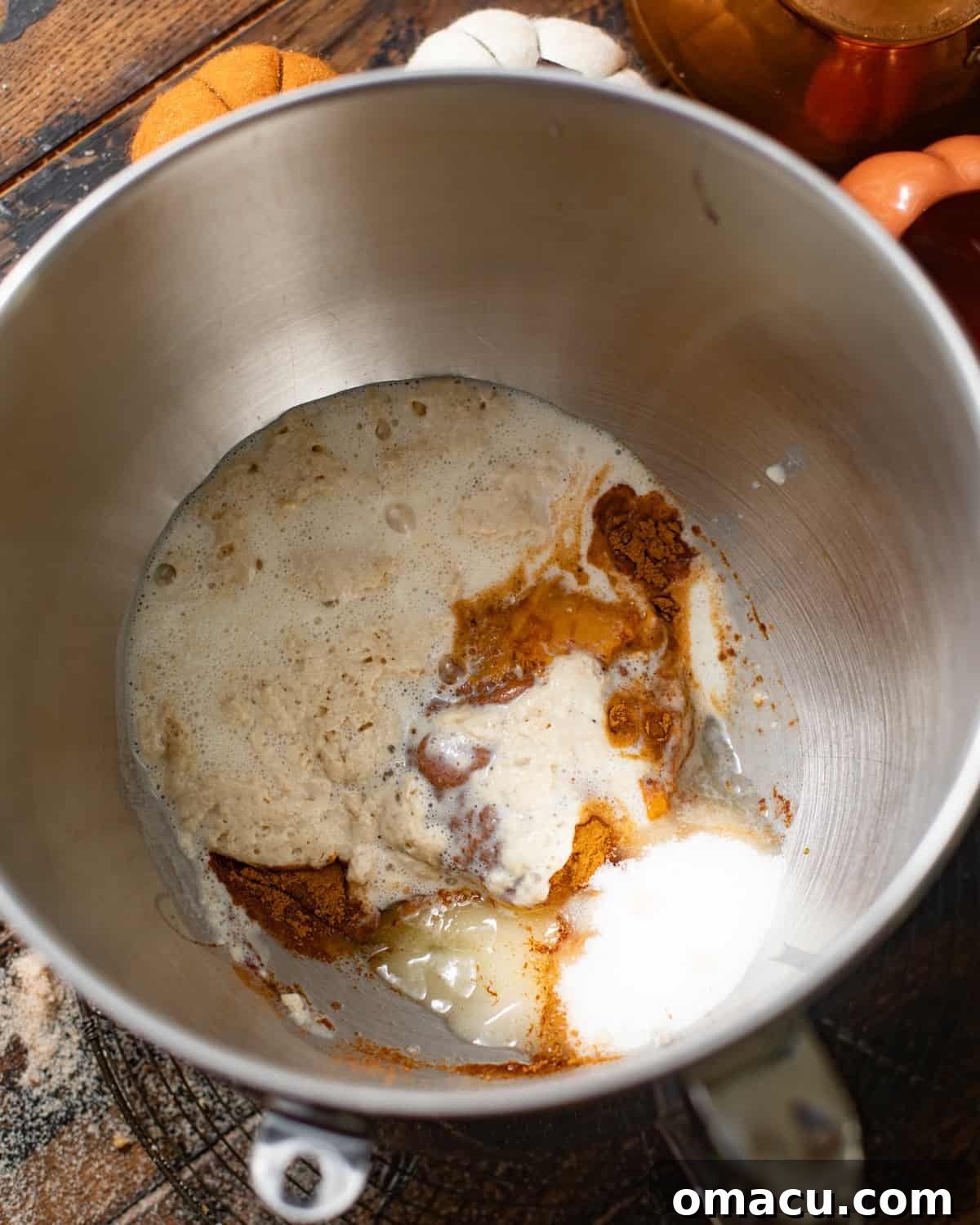A mixing bowl with wet and dry ingredients partially combined for the pumpkin brioche dough.
