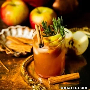 Apple Cider Whiskey Cocktail with sliced apples and rosemary sprigs for garnish.