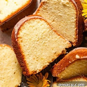 Lemon cream cheese pound cake sliced on a serving tray and topped with cream cheese glaze.