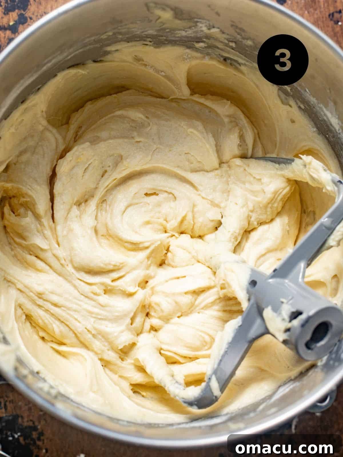 Lemon cream cheese pound cake batter in a metal mixing bowl, showcasing its smooth consistency with the paddle attachment.
