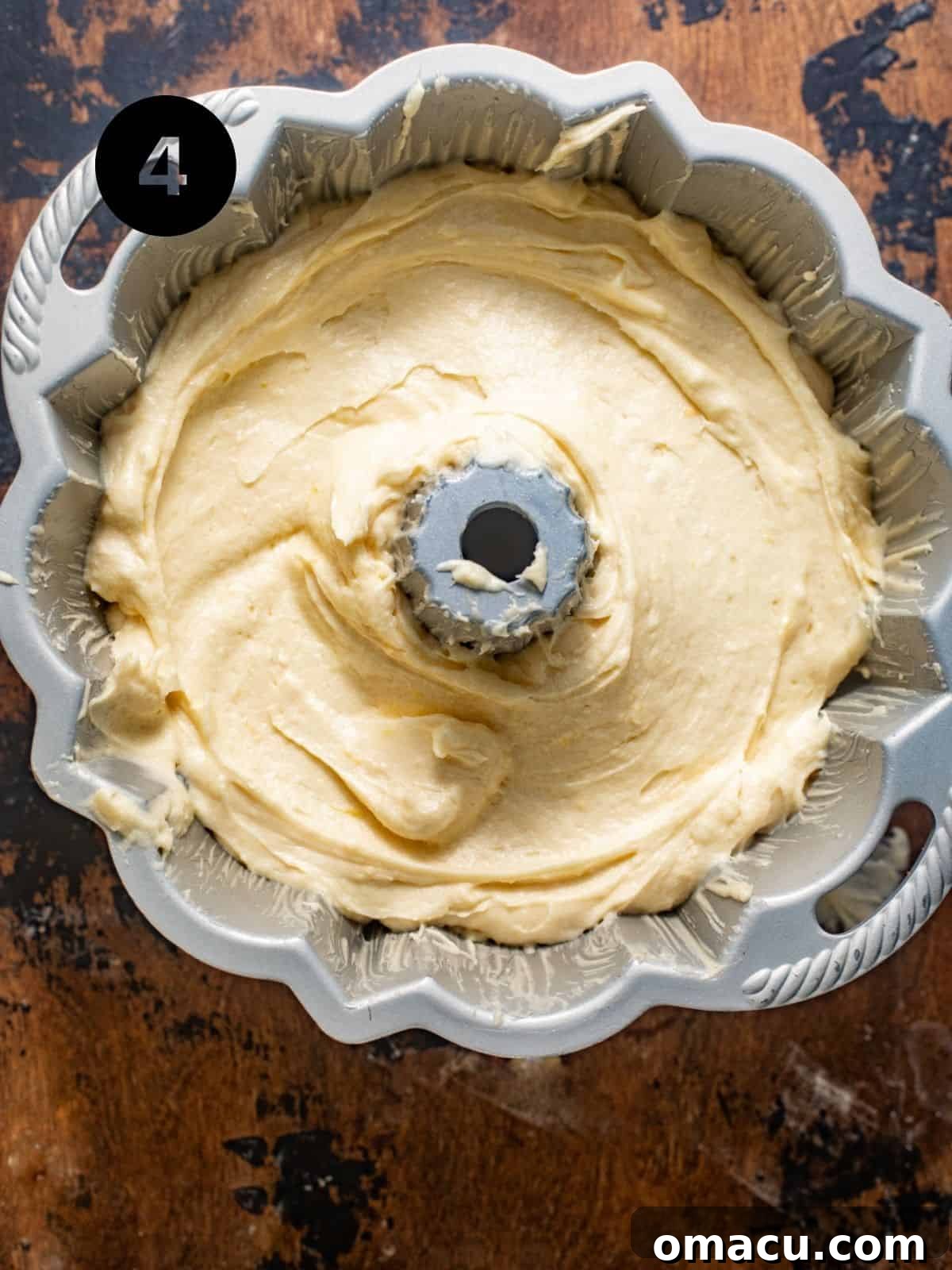 Smooth lemon cream cheese pound cake batter poured evenly into a prepared bundt pan, ready for baking.
