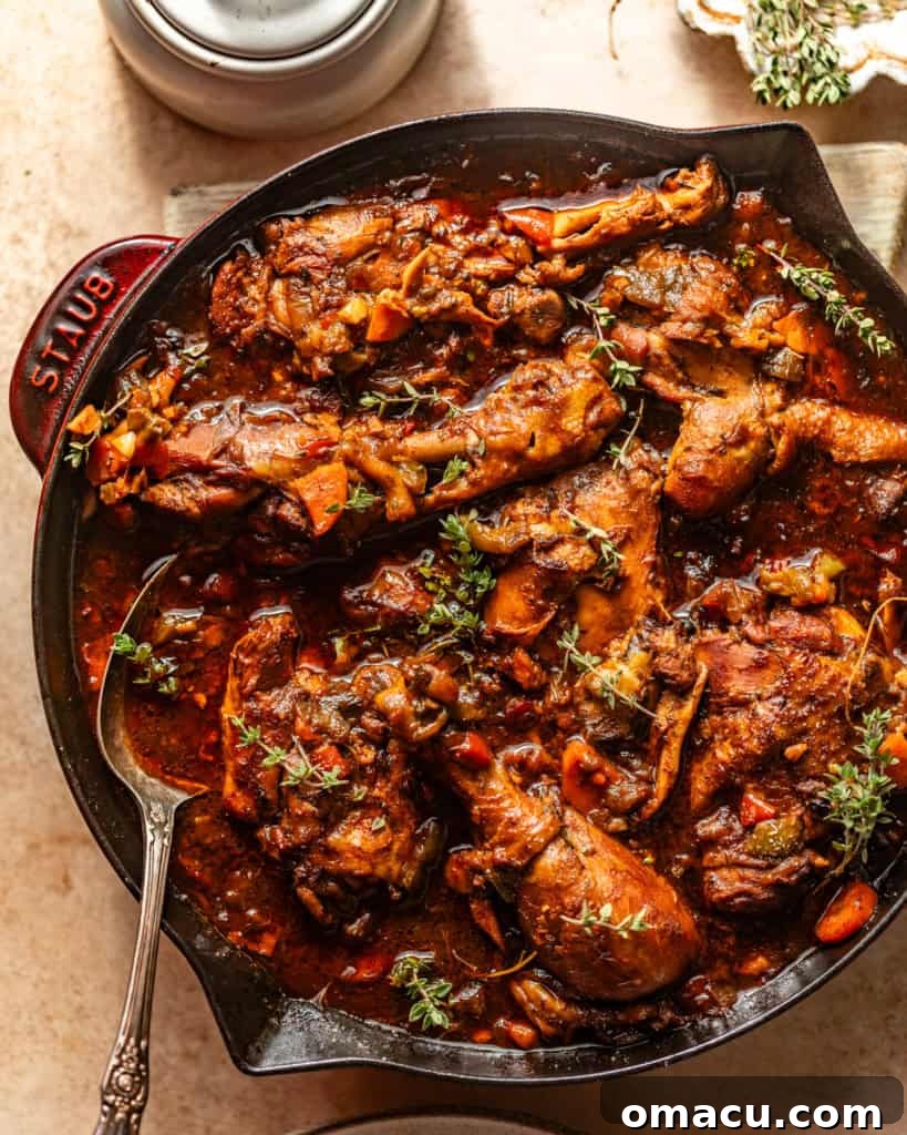 A savory brown stew chicken dish served in a rustic skillet, ready to be enjoyed.