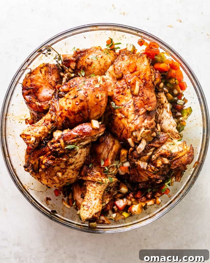 Chicken pieces thoroughly coated in a vibrant marinade in a large mixing bowl, ready for flavor infusion.