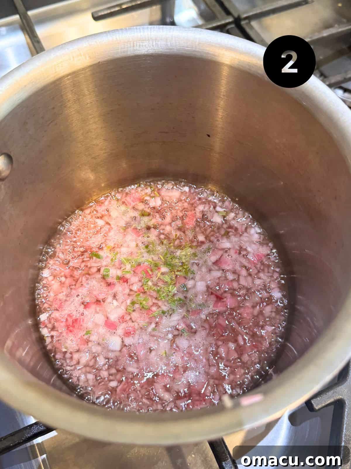 Reduced red wine vinegar in a saucepan with minced shallots, fresh tarragon, black pepper, and salt, creating the flavorful base for béarnaise sauce.