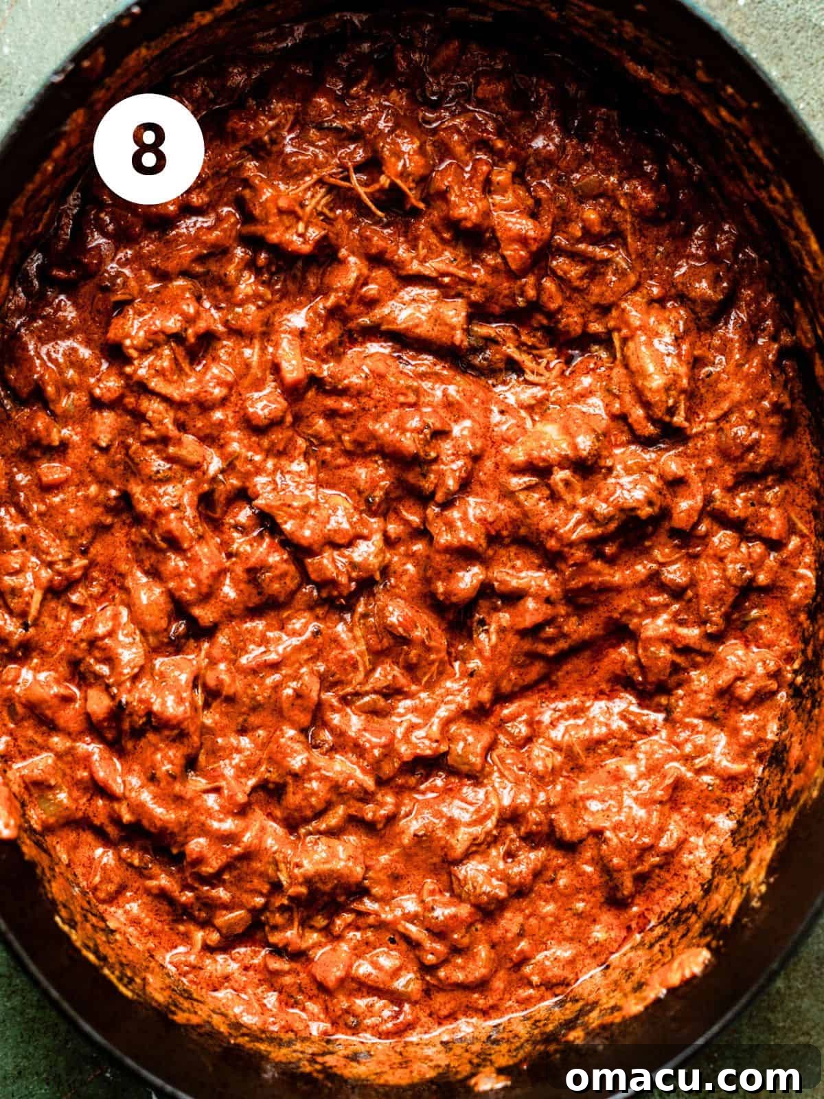 The finished short rib bolognese sauce, rich and thick, simmering gently in the pot, ready to be tossed with pasta.