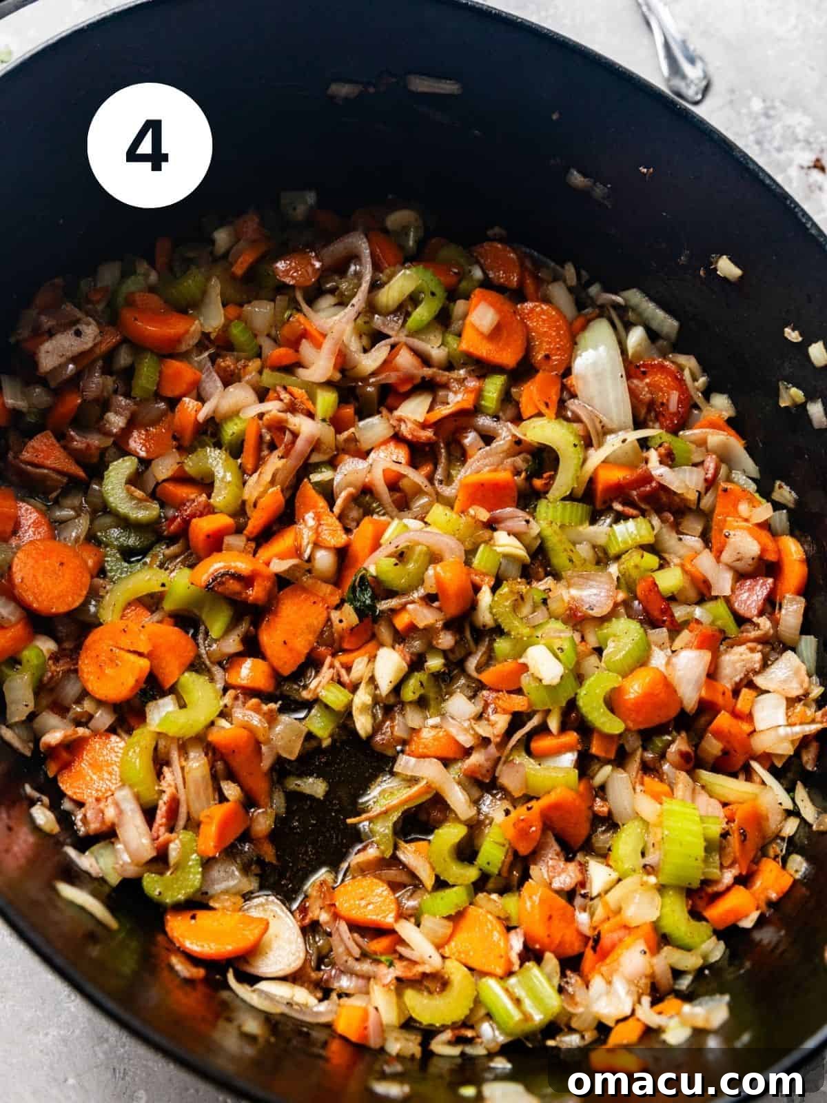 Finely diced celery, carrots, onions, and minced garlic sautéing in a Dutch oven, forming the aromatic soffritto.