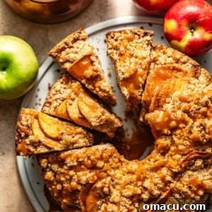 Salted caramel apple crumb cake on a plate with apples around it.