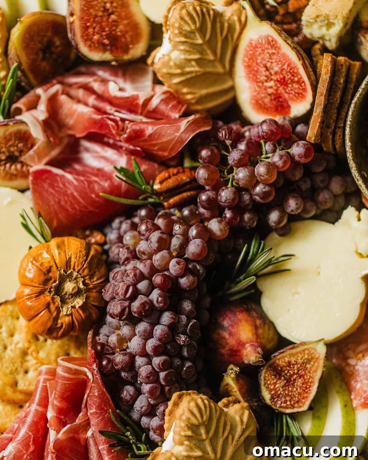 Close-up photograph focusing on an arrangement of colorful fruits and gourmet cheeses on a rustic charcuterie board.