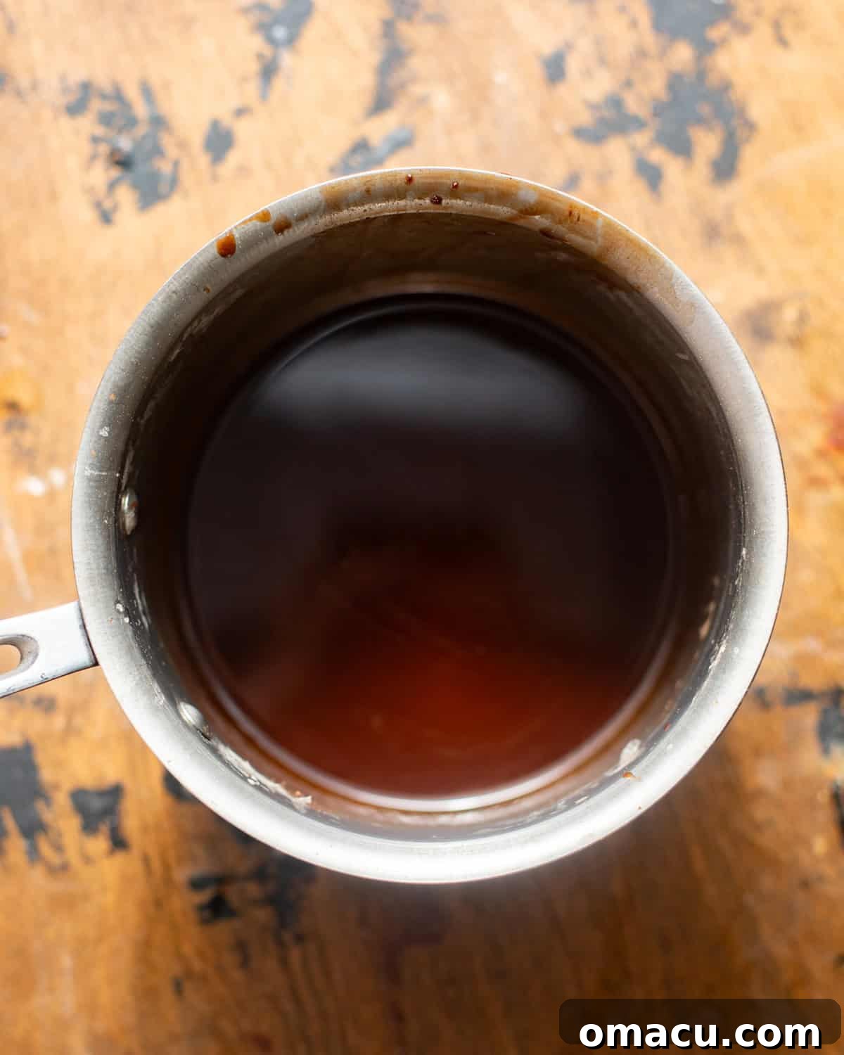 Chocolate cake soak simmering in a small saucepan on the stove, creating a rich syrup.