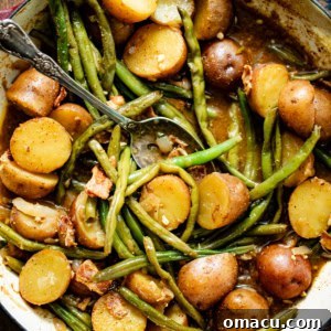 Green beans and potatoes in a large pot with a serving spoon.