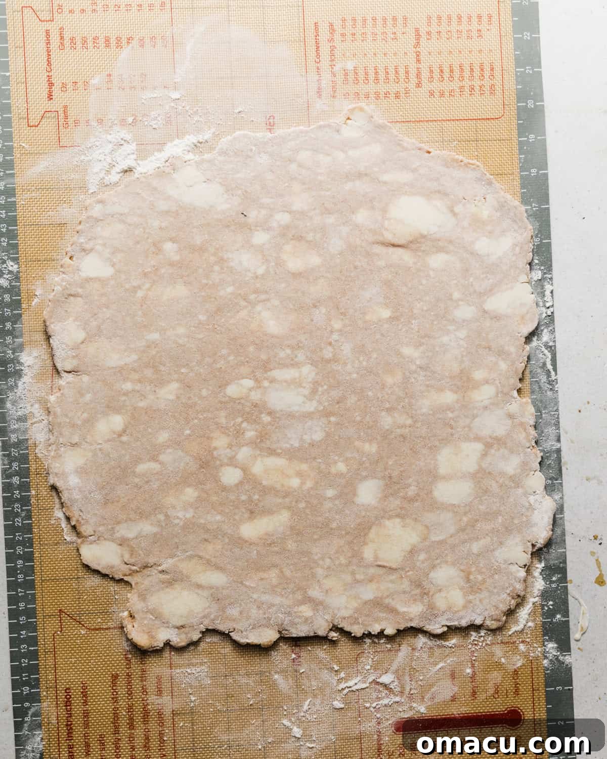 Pie crust dough rolled out evenly on a lightly floured work surface.