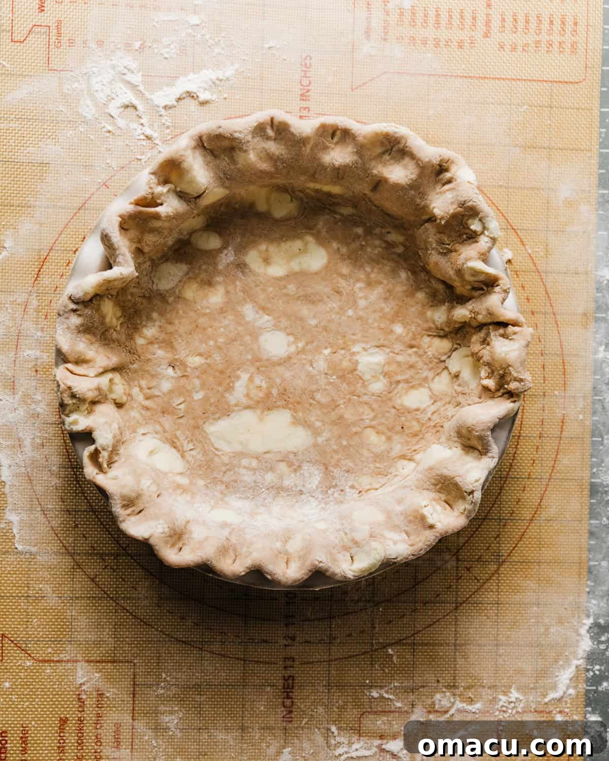 Pie crust neatly placed in a pie dish, with edges trimmed.