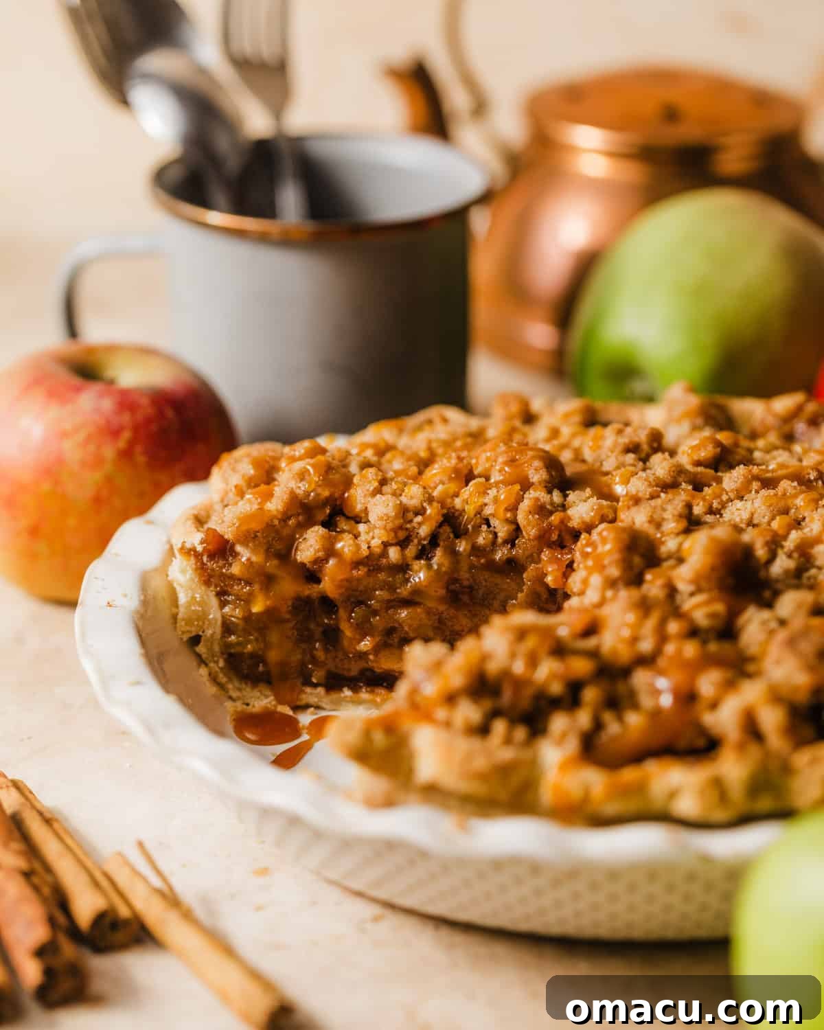 A completed salted caramel Dutch apple pie in a pie dish, with a golden streusel topping, ready to be served.