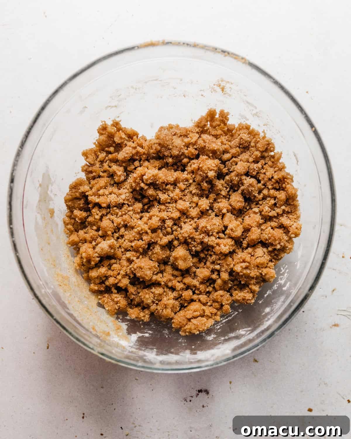 Crumble topping mixed together in a bowl, showing a coarse, buttery texture.