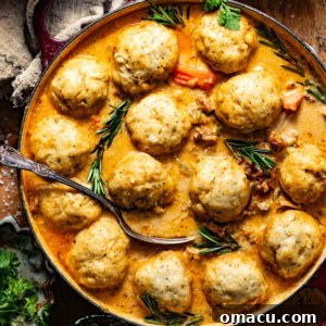 chicken and dumplings in a dutch oven with a serving spoon and fresh parsley on top.