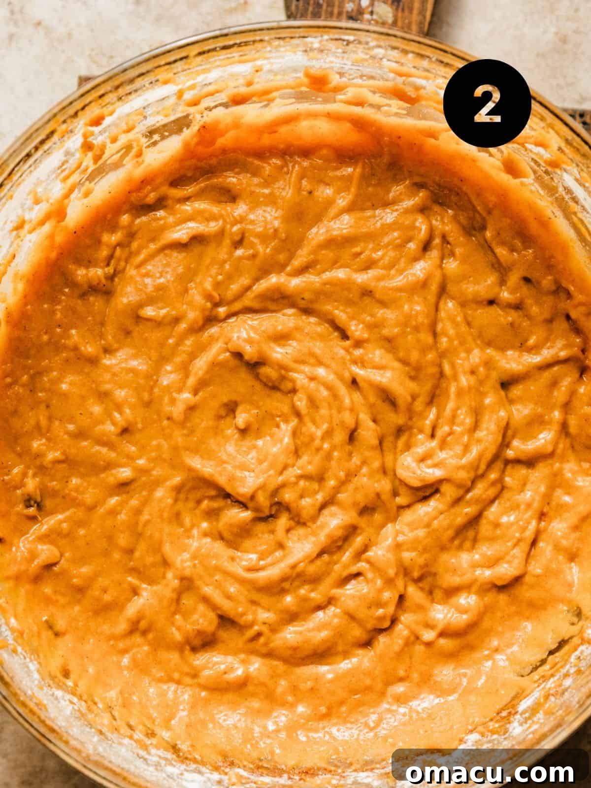 The sweet potato bread batter, perfectly mixed and smooth, in a large mixing bowl, ready for transfer to the loaf pan.