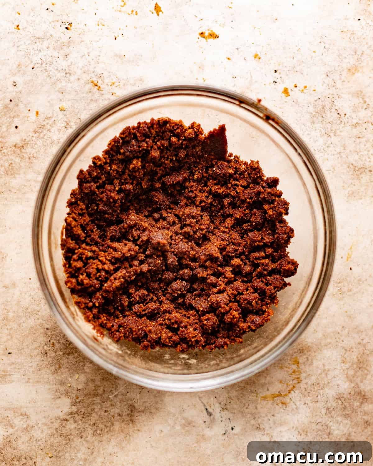 Cinnamon crunch topping mixed together in a small mixing bowl, resembling wet sand.
