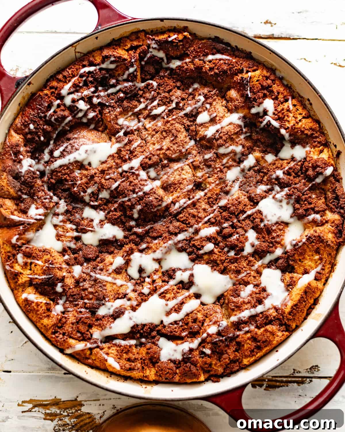 Freshly baked bread pudding in a pan, generously coated with the warm vanilla sauce.