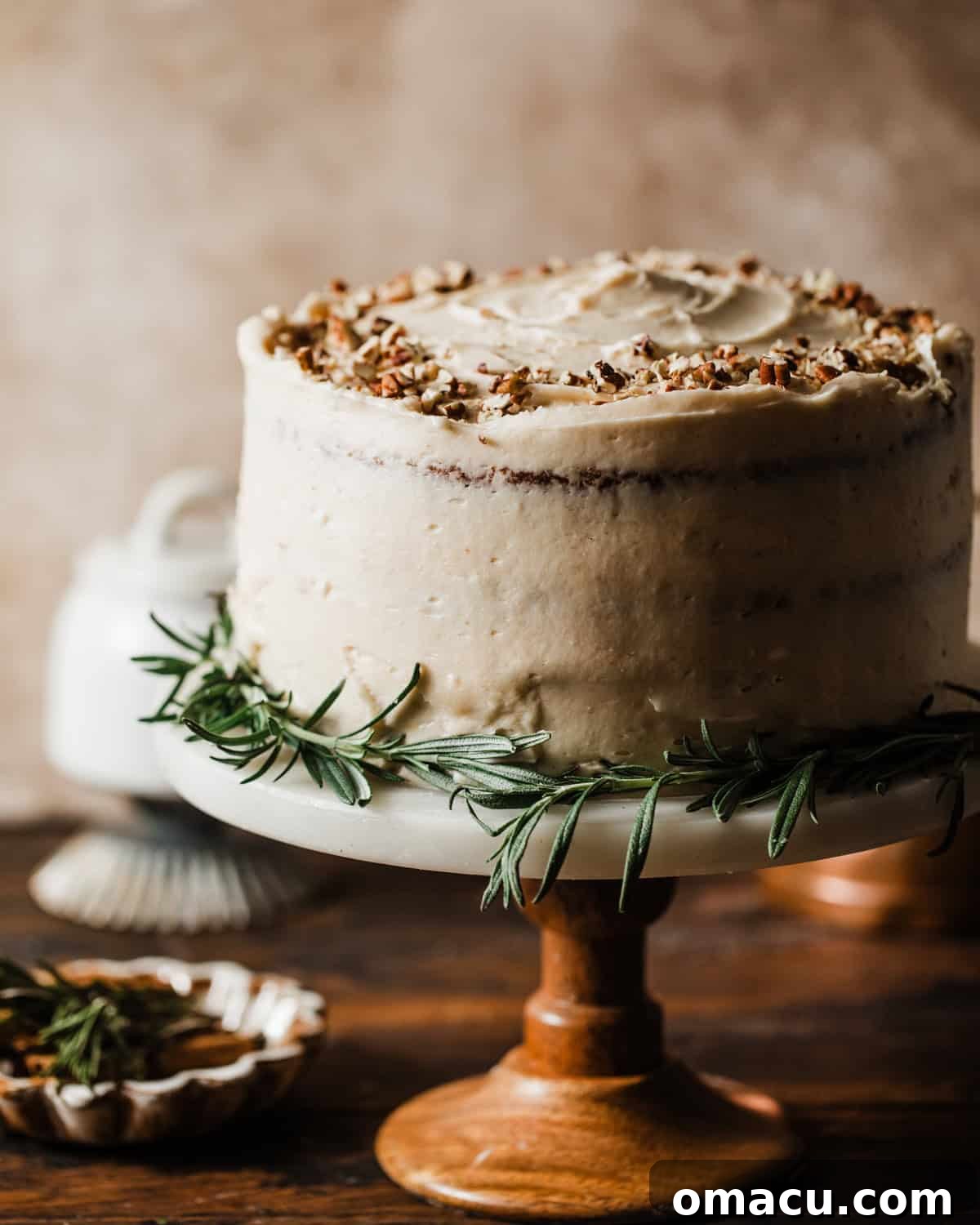 A beautifully decorated carrot cake on a cake stand, ready to be served.