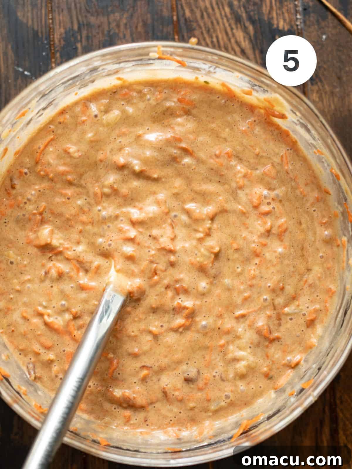 Carrot cake batter with shredded carrots, crushed pineapple, and pecans folded in.