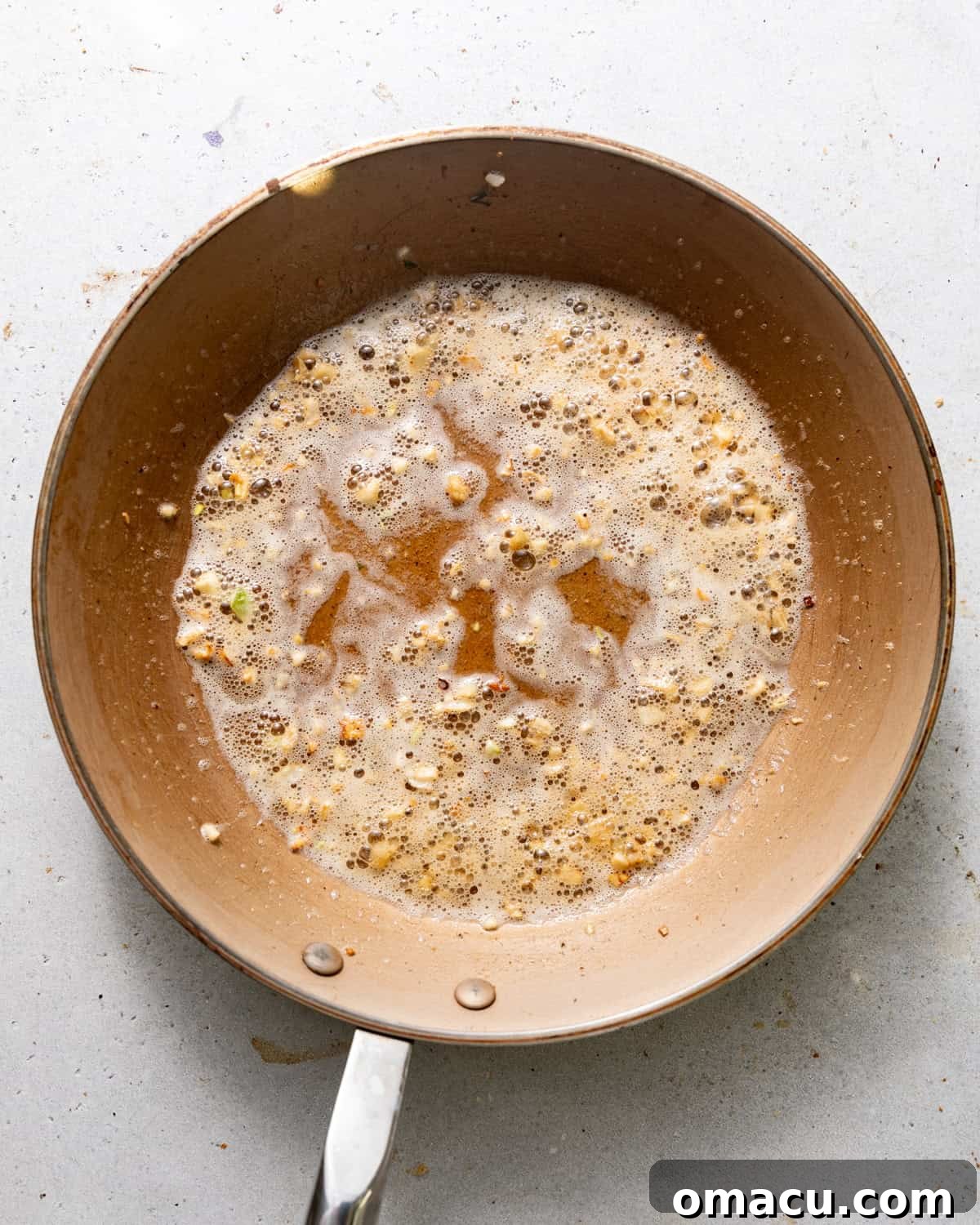 Garlic and butter sizzling in a skillet with cajun seasoning and lemon juice.