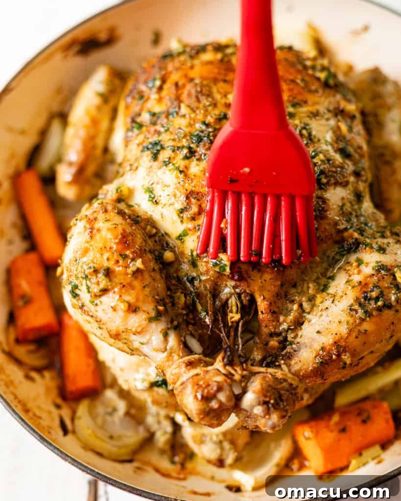 roasted chicken in a pan covered in garlic butter sauce.