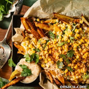 Elotes fries in a serving basket with queso on top, a delicious and vibrant appetizer.