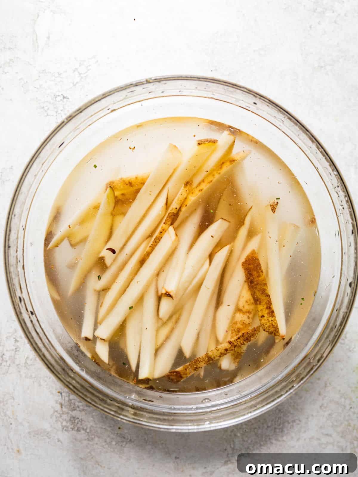 Cut potatoes soaking in a large bowl of ice water to remove excess starch.