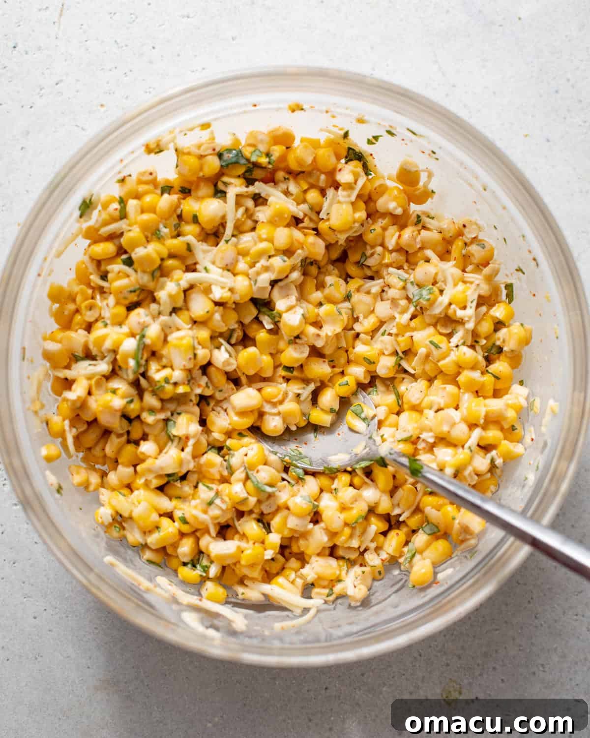 A bowl filled with elotes corn mixture, creamy and ready to be topped on fries.