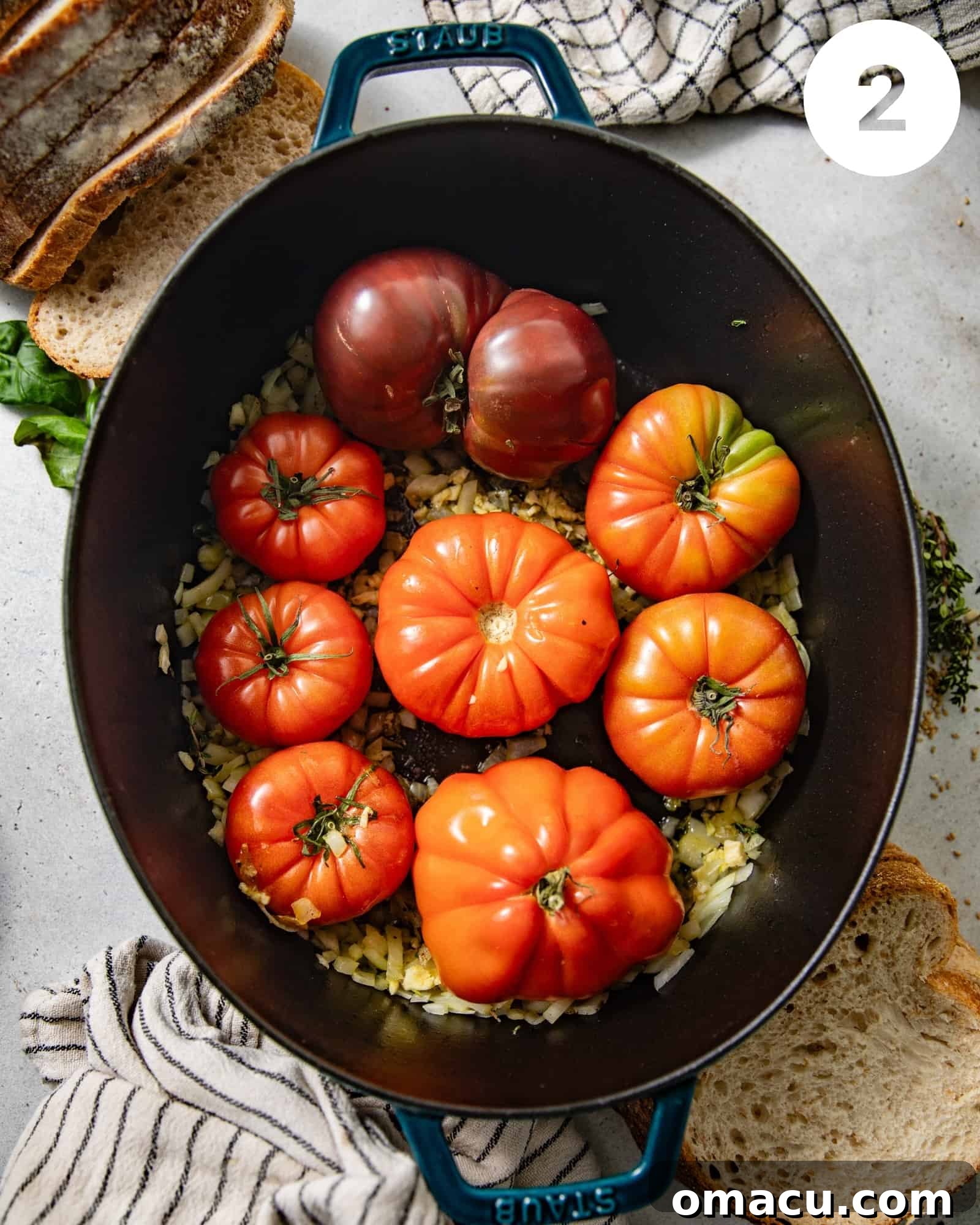 Heirloom tomatoes, olive oil, onions, garlic, thyme, and shallots mixed in a large pot before roasting.