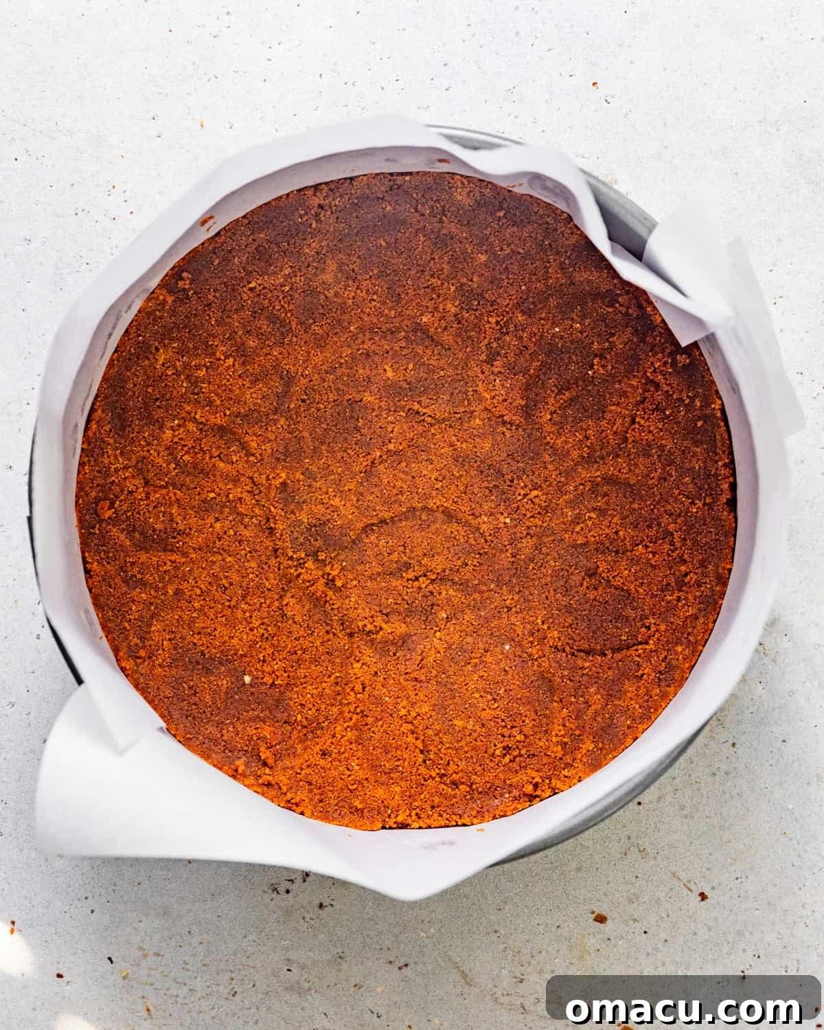 A perfectly formed Biscoff cookie crust pressed evenly into the bottom and slightly up the sides of a springform pan.