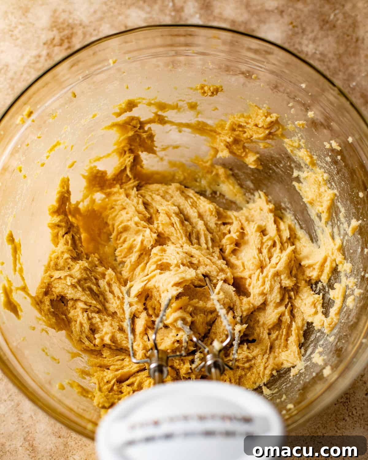 Creamed butter, sugar, and brown sugar mixed together in a stand mixer bowl, showing a light and fluffy texture.