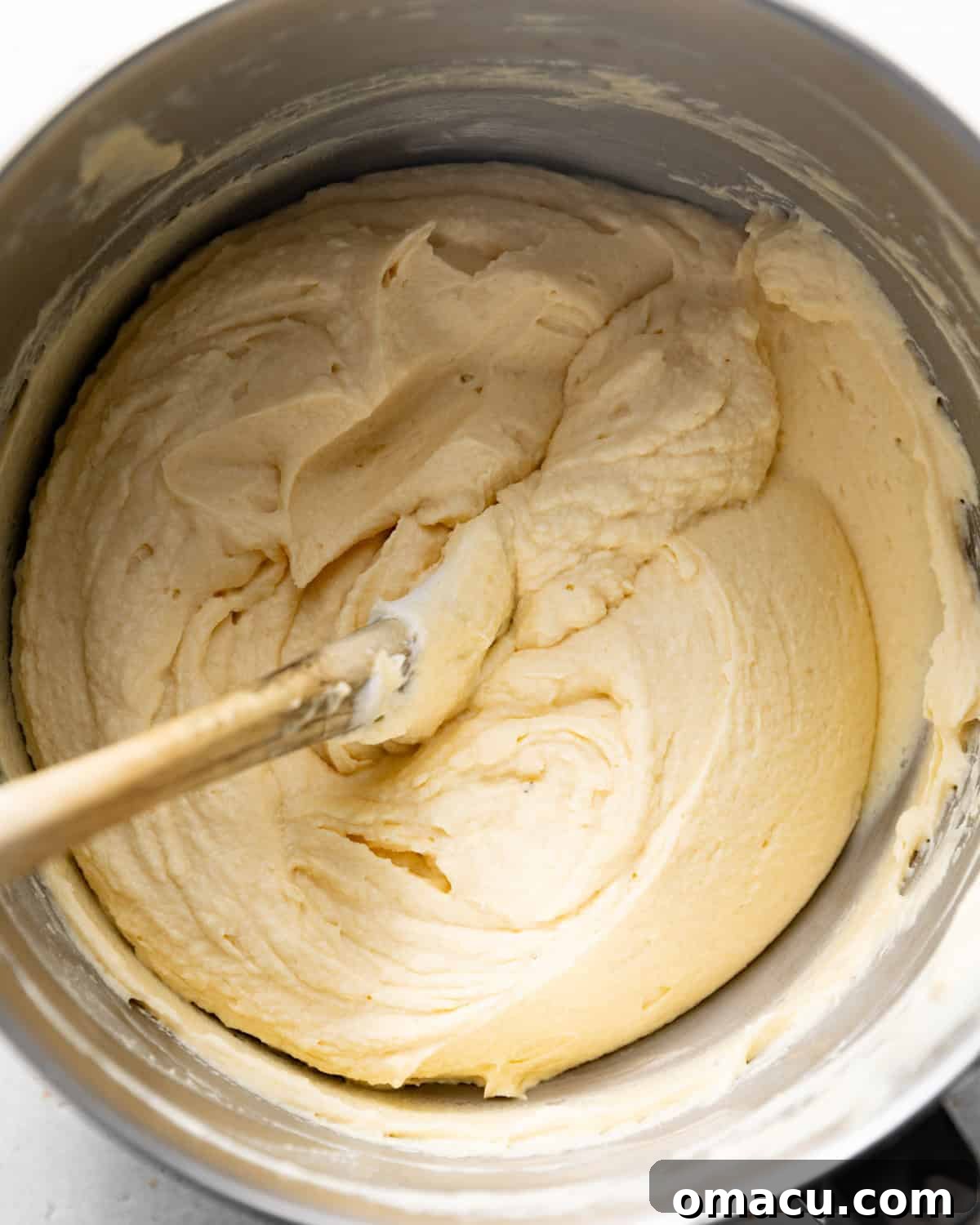 Cold heavy cream, rich vanilla bean paste, fragrant espresso powder, and a pinch of kosher salt being whipped in the bowl of a stand mixer, forming the fluffy base for tiramisu cream.